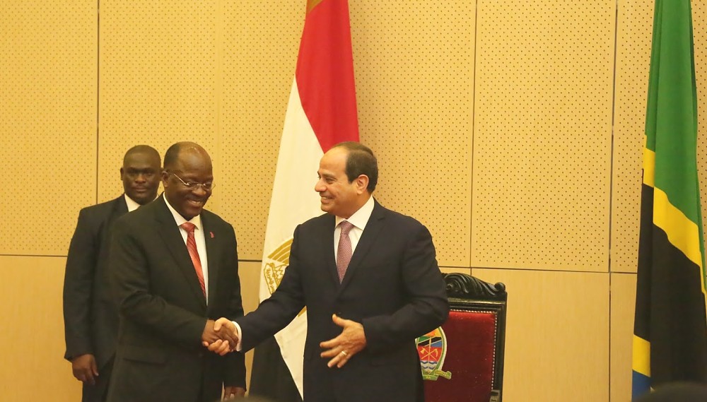 Egyptian President Abdel Fattah El-Sisi shakes hands with  his host after making his address